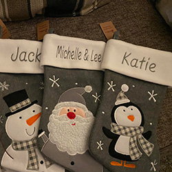 Embroidered Christmas stockings with Jack, Michelle & Lee, and Katie on them